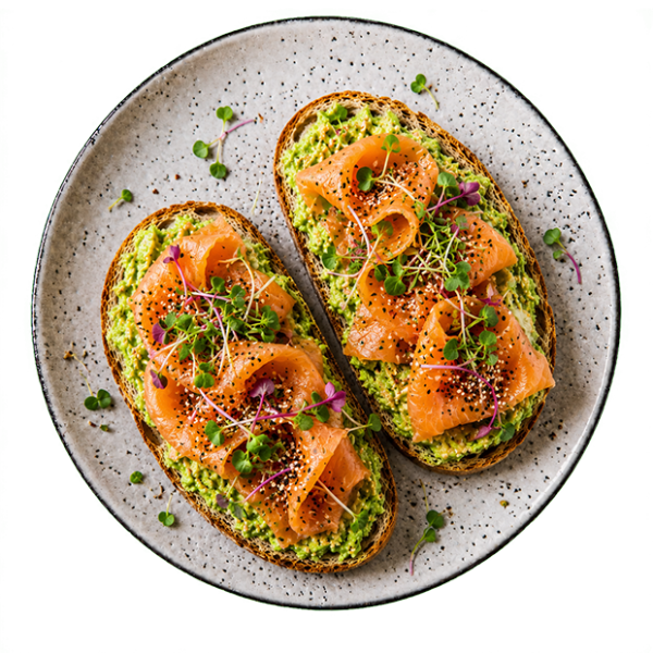 Zwei Avocado-Toasts mit Lachs und Kresse, auf einem hellen, gesprenkelten Keramikteller.