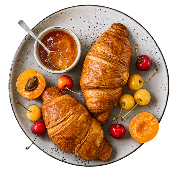 Zwei Croissants mit Aprikosenmarmelade, Kirschen und Aprikosen auf einem gesprenkelten Keramikteller